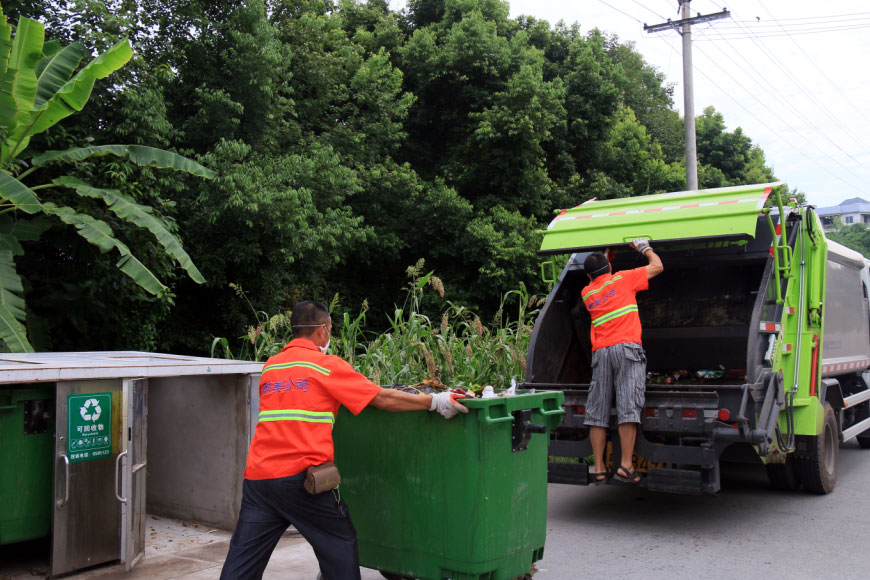 区环卫新购置的压缩式垃圾车正在清运作业